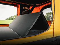 Close up of TentBox BackRest set up inside an orange Classic 2.0 with a view through the windows of grass and trees in the background.
