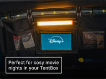 Tablet and LED Bar Light lit up inside a dark TentBox with text that reads 'Perfect for cosy movie nights in your TentBox.'